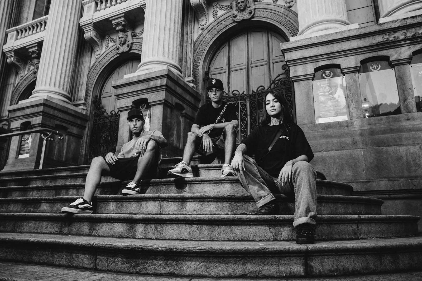 Trio de modelos na escadaria monumental, em preto e branco granulado