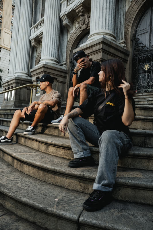 Trio sentado nos degraus, camisetas pretas