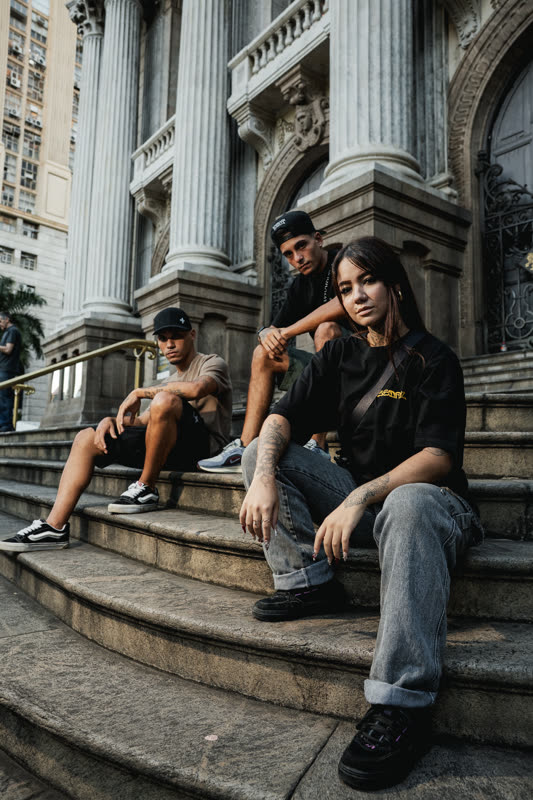 Trio nos degraus com prédio ao fundo